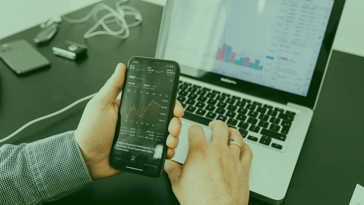 Valor de mercado: pessoa consultando dados financeiros no celular e no computador